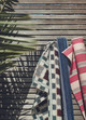 Lapaz, Maya and Verano outdoor fabric rolls lent against a wooden fence.